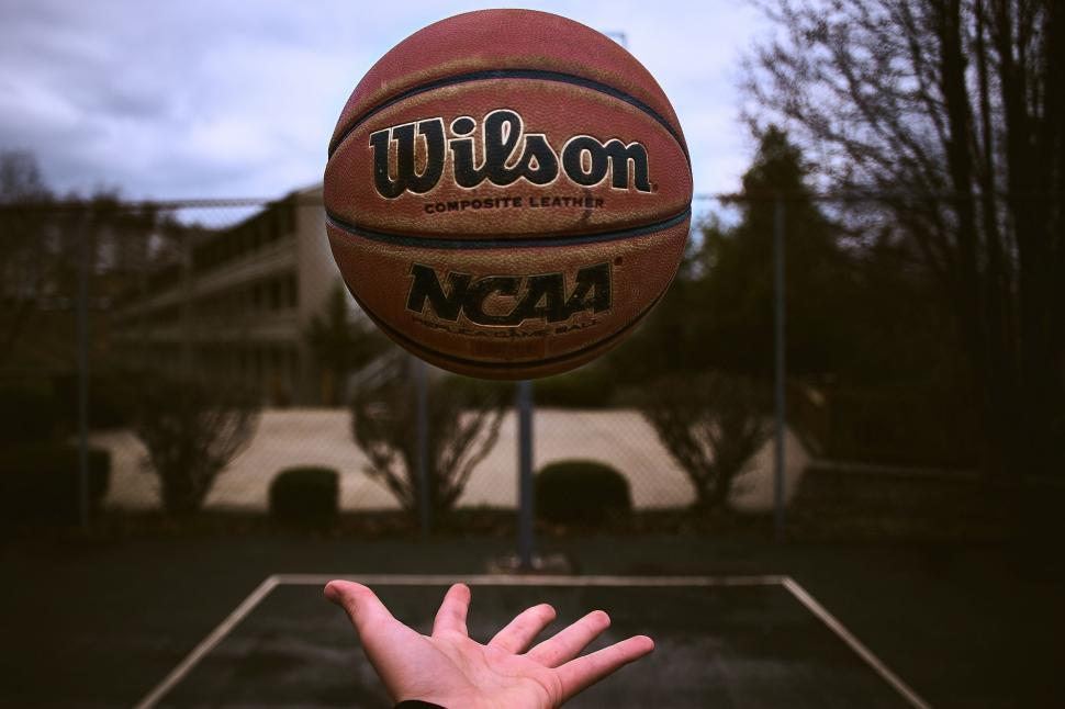 Free Image of Person Reaching Up to Basketball in the Air 