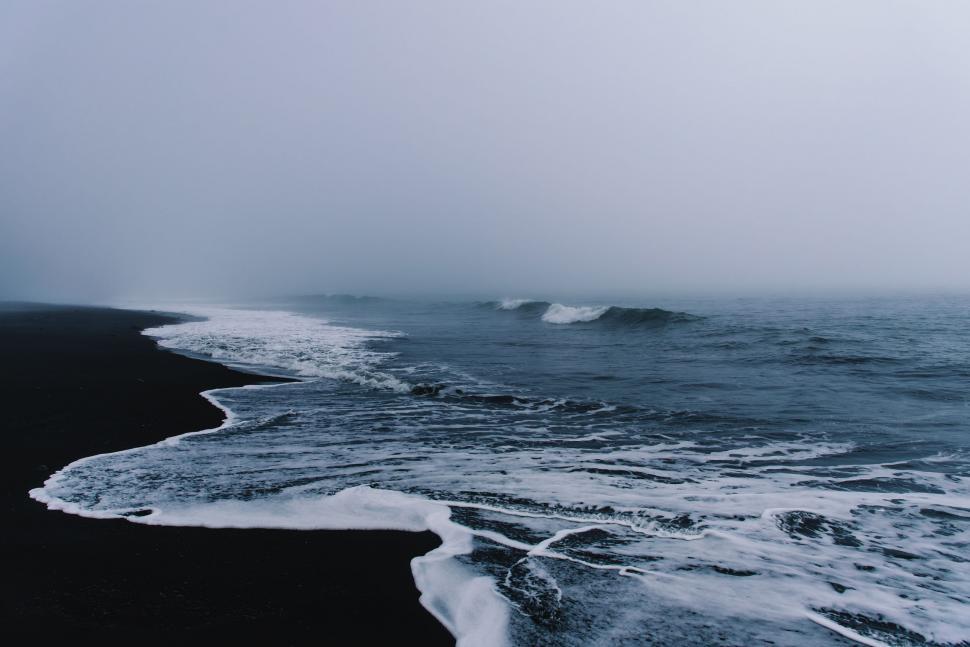 Free Image of Waves Crashing on Rocky Shore Under Stormy Sky 
