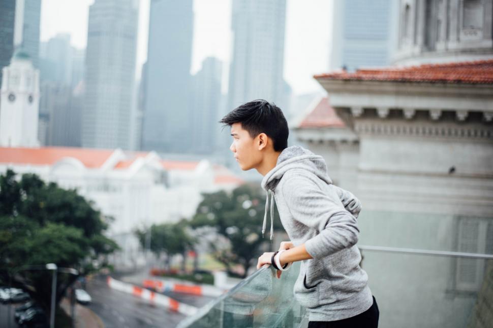 Free Image of Man Standing on Roof Next to Tall Building 