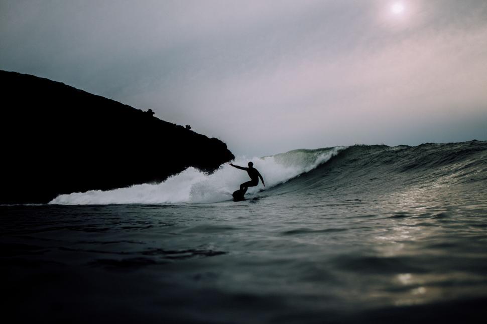 Free Image of Man Riding a Wave on Surfboard 