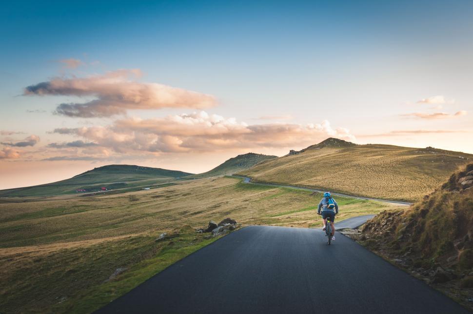 Free Image of Person Riding a Bike Down a Road 