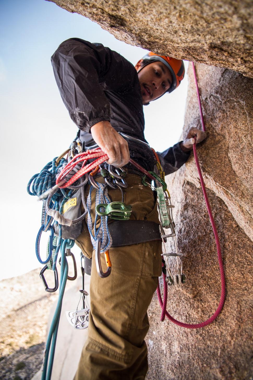 Free Image of Man Climbing Up the Side of a Mountain 