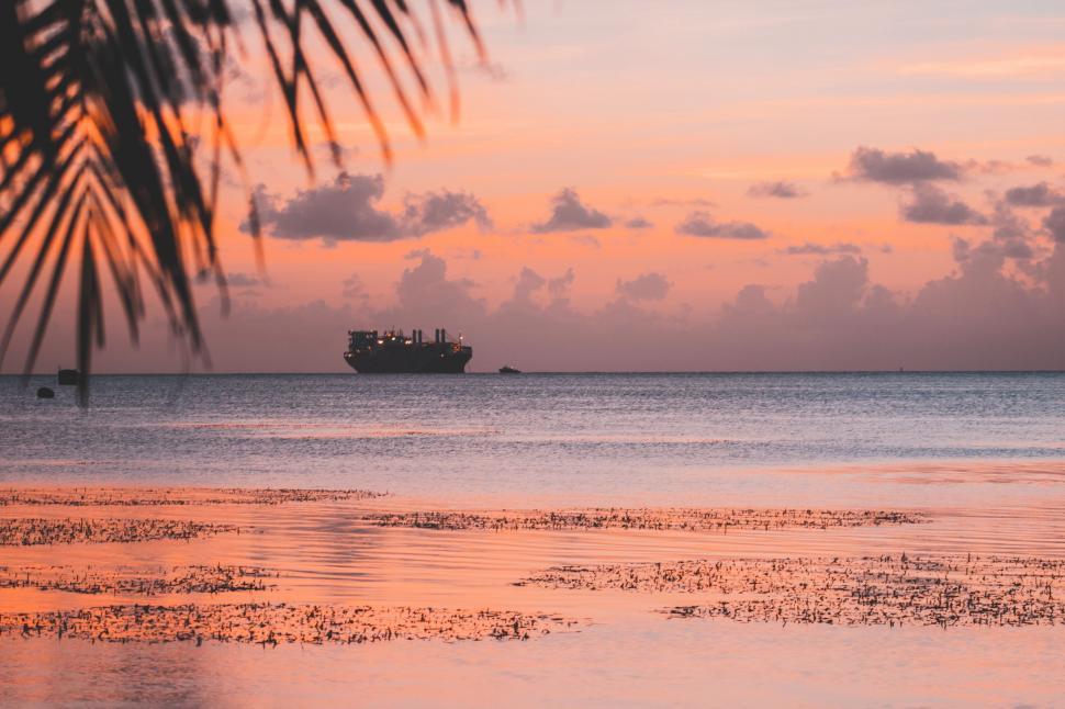 Free Image of Boat Sails in the Ocean at Sunset 
