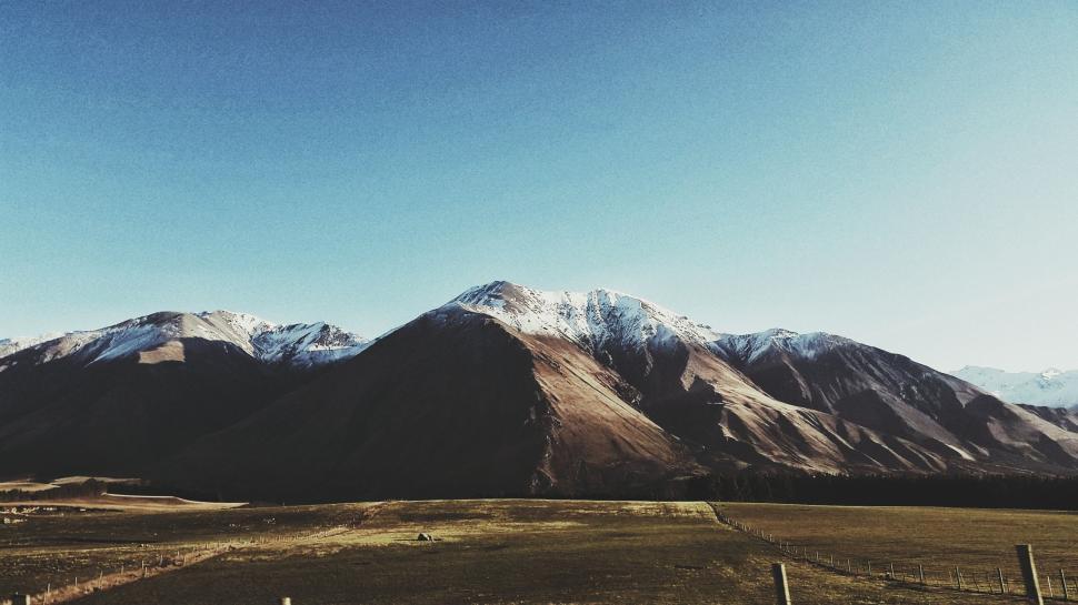 Free Image of Field With Fence and Mountains in Background 