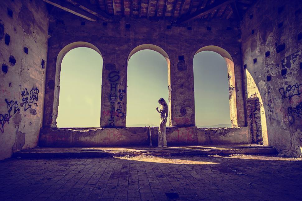 Free Image of Person Standing in Room With Four Windows 