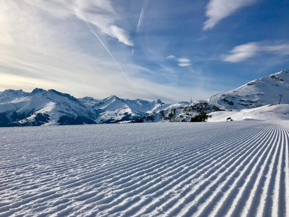 Free Image of Snow Covered Ski Slope With Mountains Background 