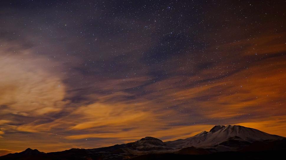 Free Image of Night Sky With Stars and Clouds Over a Mountain 