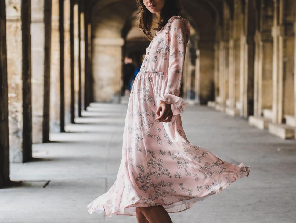 Free Image of Woman in Pink Dress Standing on Sidewalk 