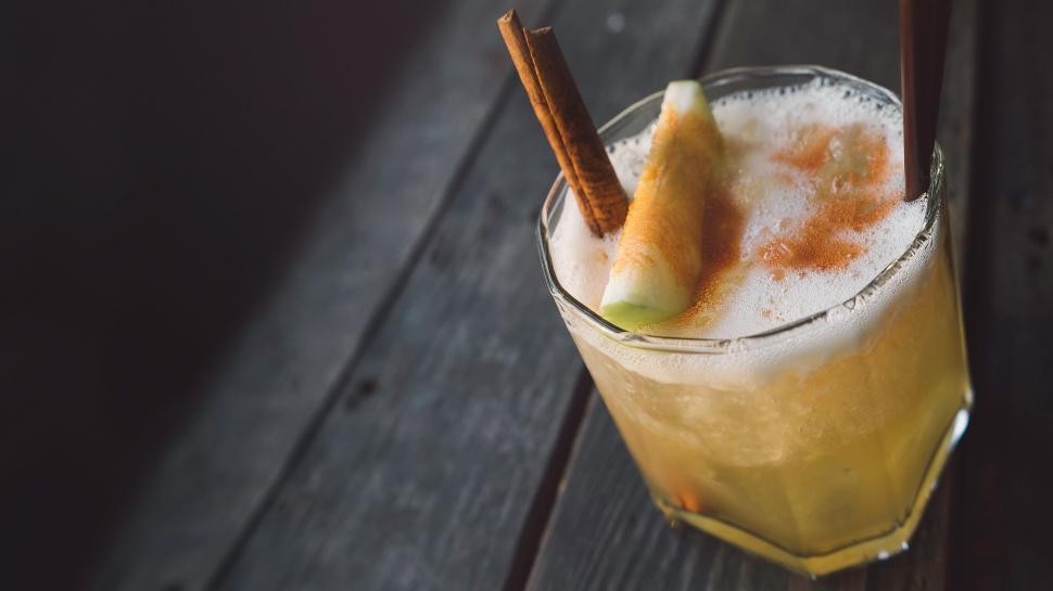 Free Image of Glass of Orange Juice With Cinnamon Sticks 