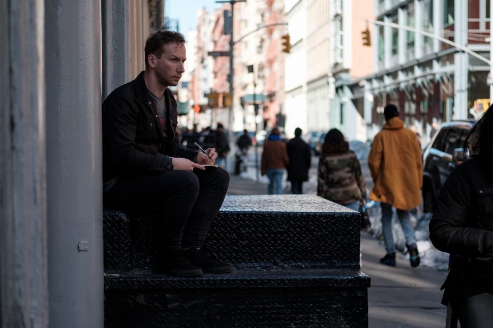 Free Image of Man and Woman Sitting on Ledge 