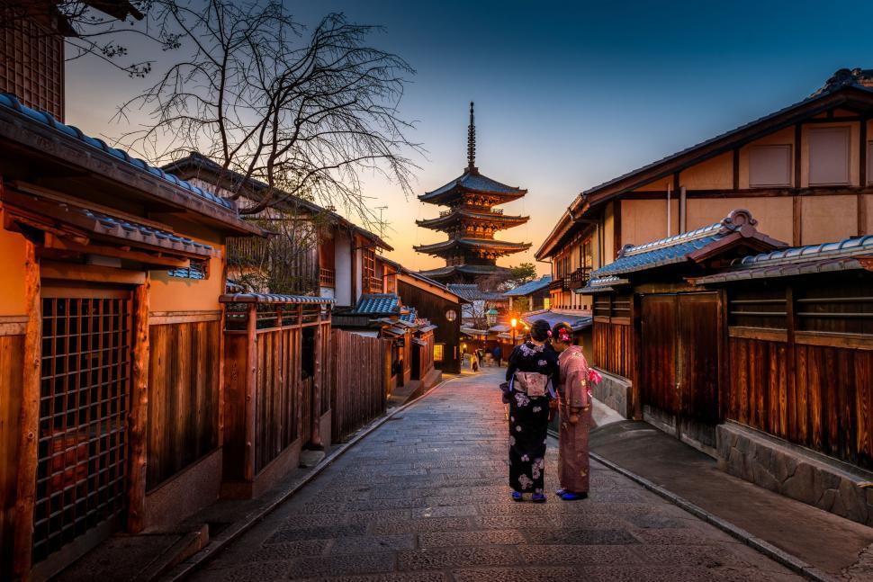 Free Image of A Couple Walking Down a City Street 