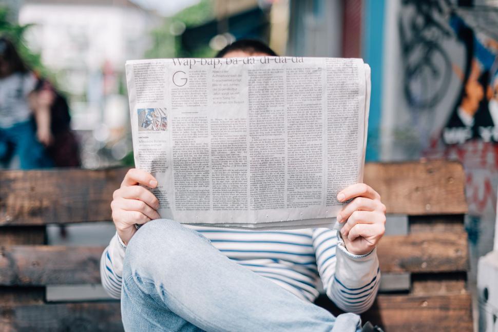 Free Image of Man Sitting on Bench Reading Newspaper 