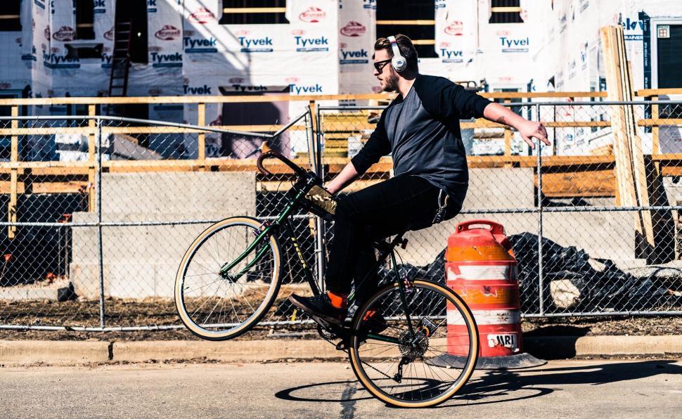Free Image of Man Riding Bike Next to Fire Hydrant 