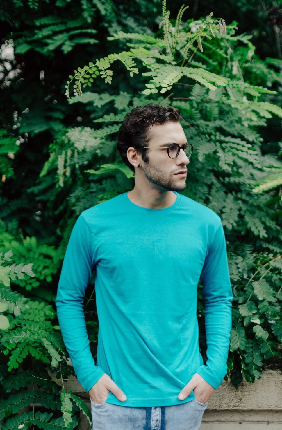 Free Image of Man Standing in Front of Bush With Hands in Pockets 