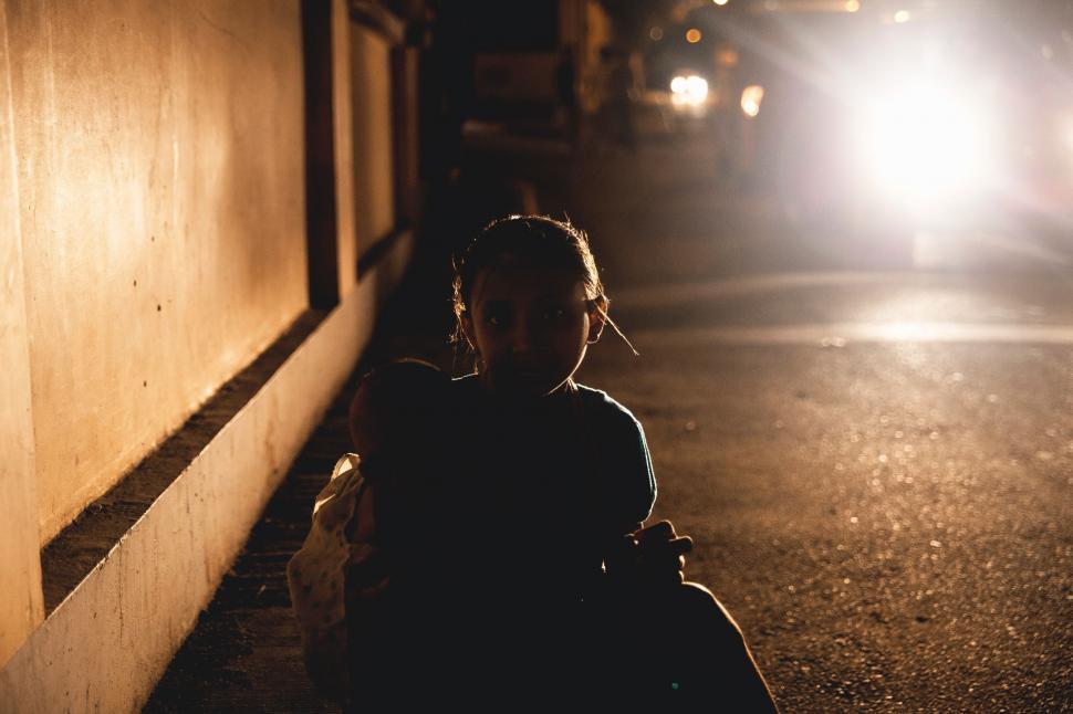 Free Image of Person Sitting on Side of Building at Night 