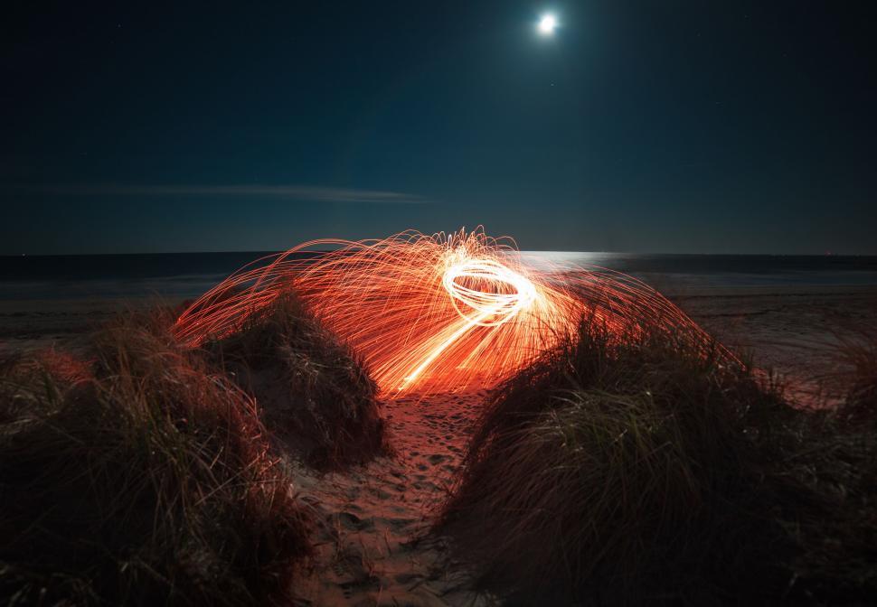 Free Image of Person Standing on Top of Sandy Beach Under Full Moon 