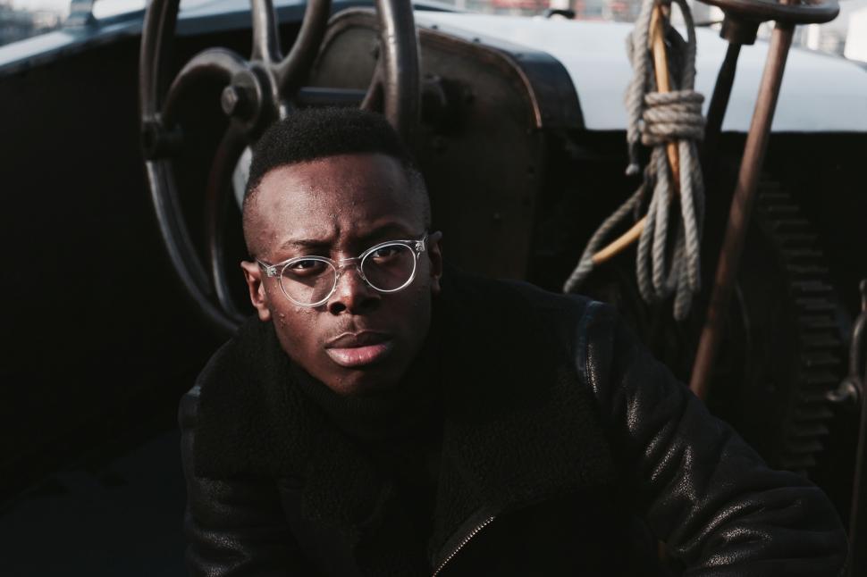 Free Image of Man Wearing Glasses Sitting on a Boat 