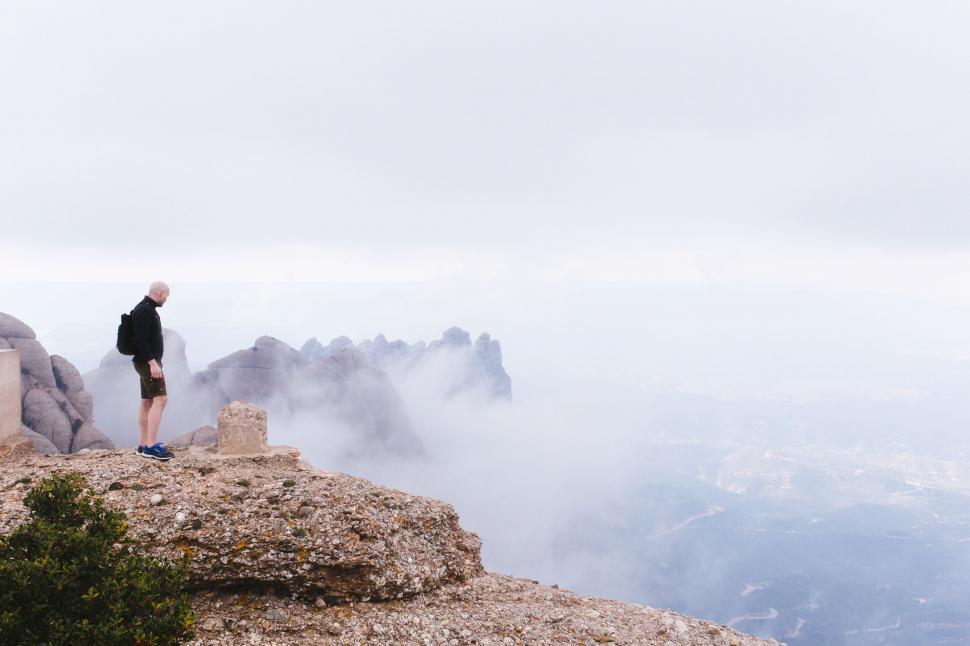 Free Image of Man Standing on Top of a Mountain 