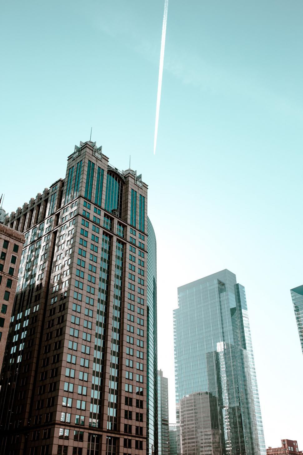 Free Image of Plane Flying Over City With Tall Buildings 