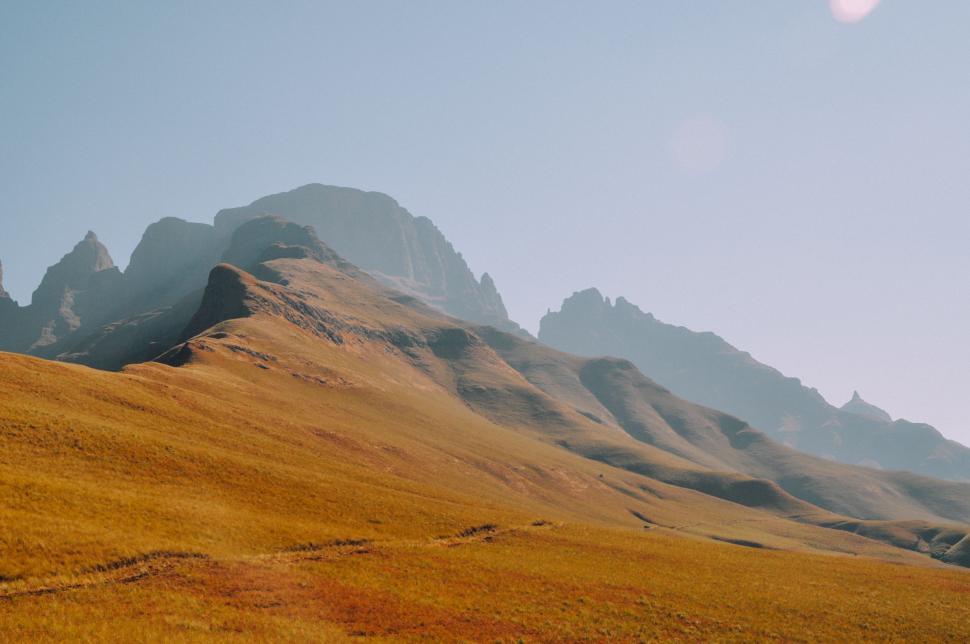 Free Image of Grassy Field With Mountains in the Background 