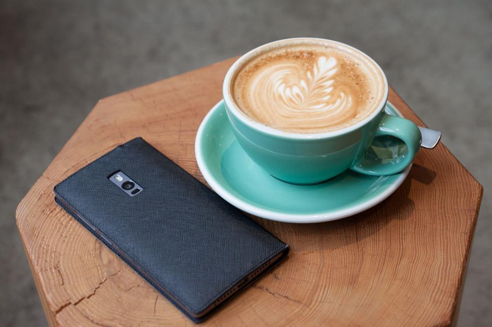 Free Image of Coffee Cup and Cell Phone on Table 