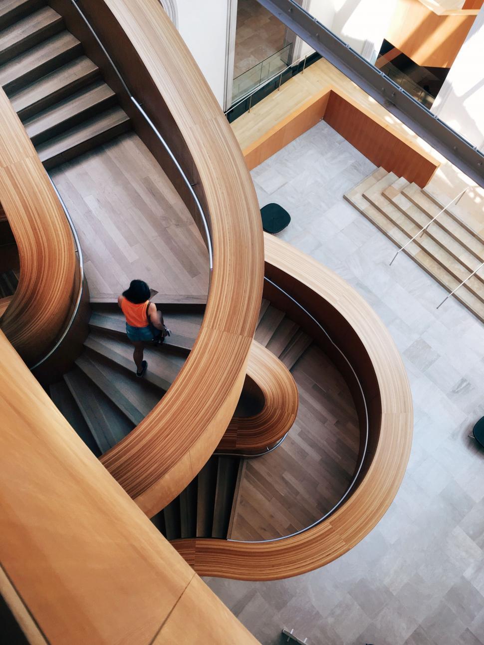 Free Image of Person Walking Down a Spiral Staircase in a Building 