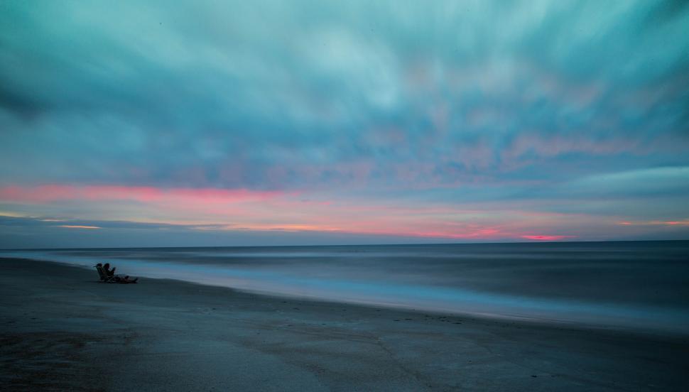 Free Image of Person Sitting on Bench on Beach 