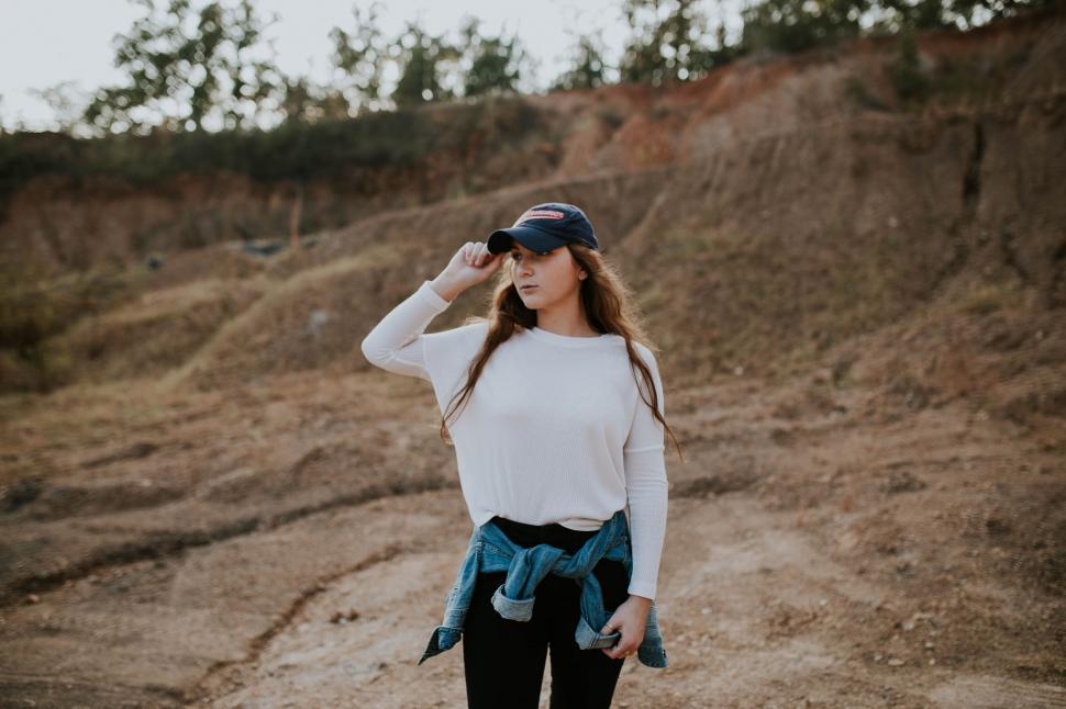 Free Image of Woman Standing on Dirt Road Wearing Hat 