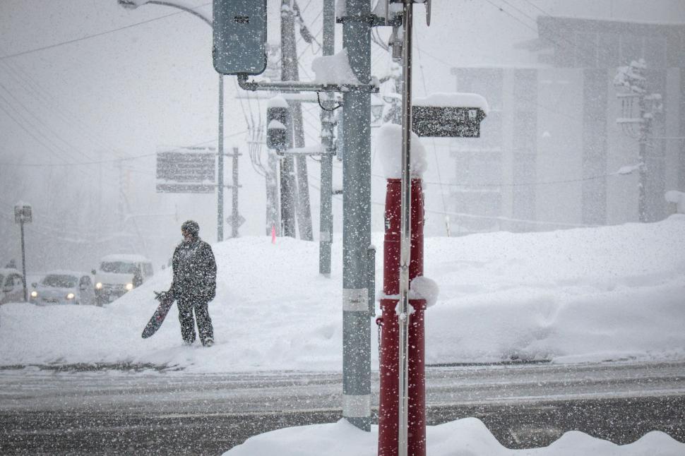 Free Image of Person Walking Across Snow Covered Street 