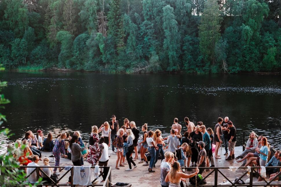 Free Image of A Group of People Standing on a Pier Next to a Lake 