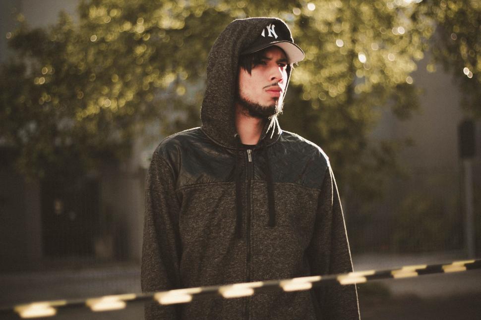 Free Image of Man in Hoodie Standing Before Police Tape 