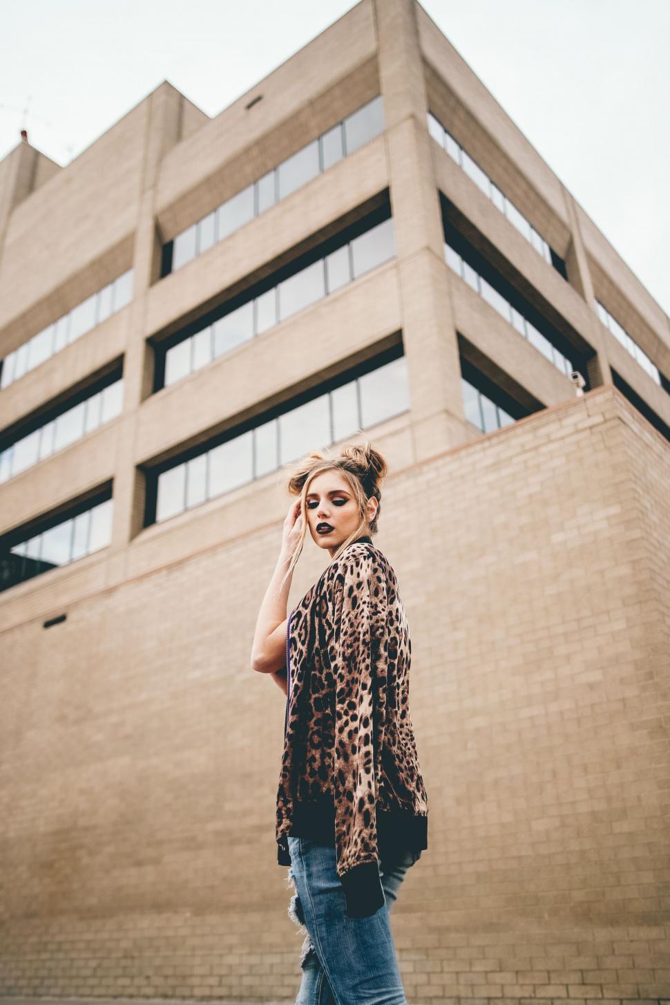 Free Image of Woman Standing in Front of Tall Building 