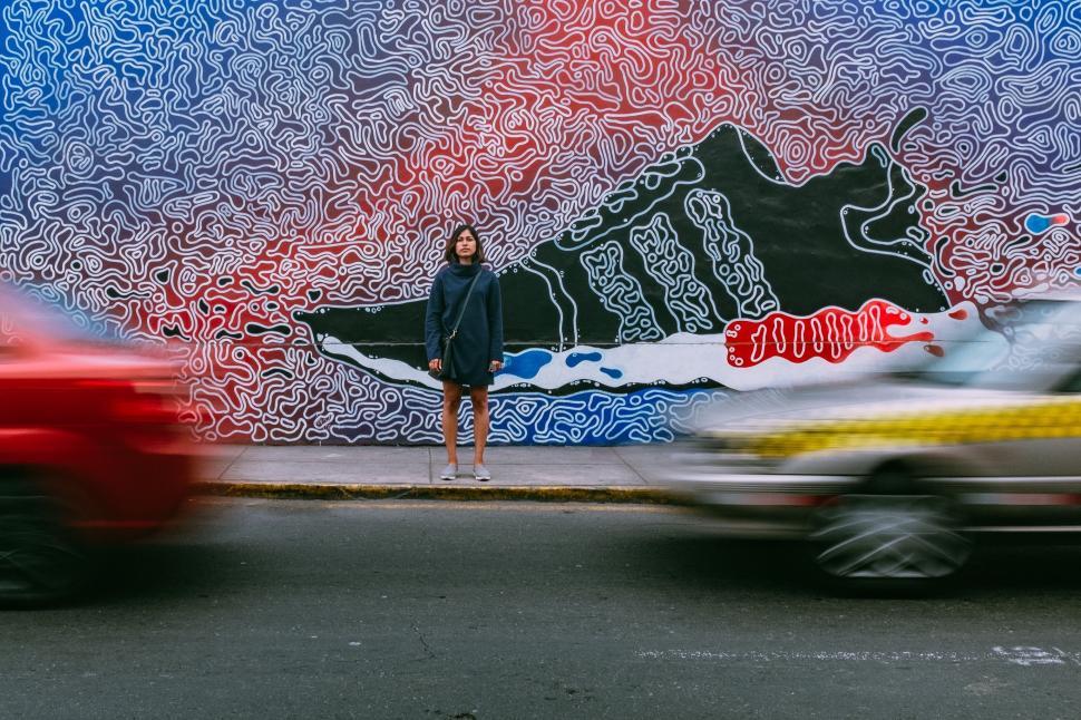 Free Image of Woman Standing in Front of Graffiti Wall 