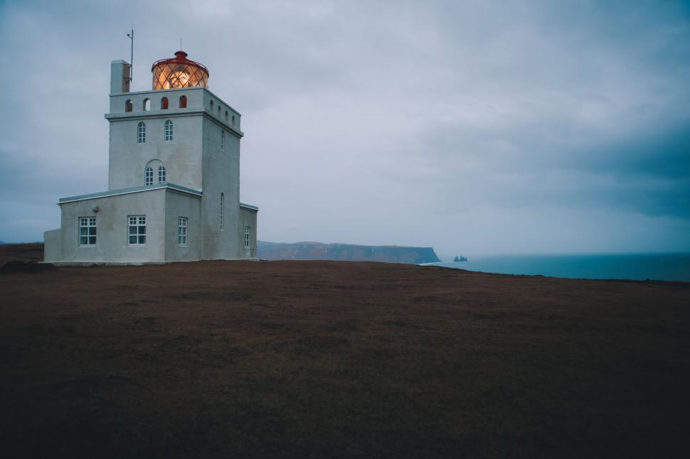 Free Image of Lighthouse on a Hill With a Sky Background 