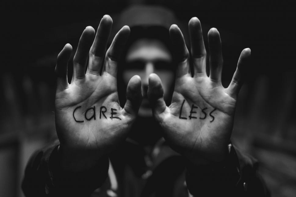 Free Image of Man Covering Face With Care Less Written 