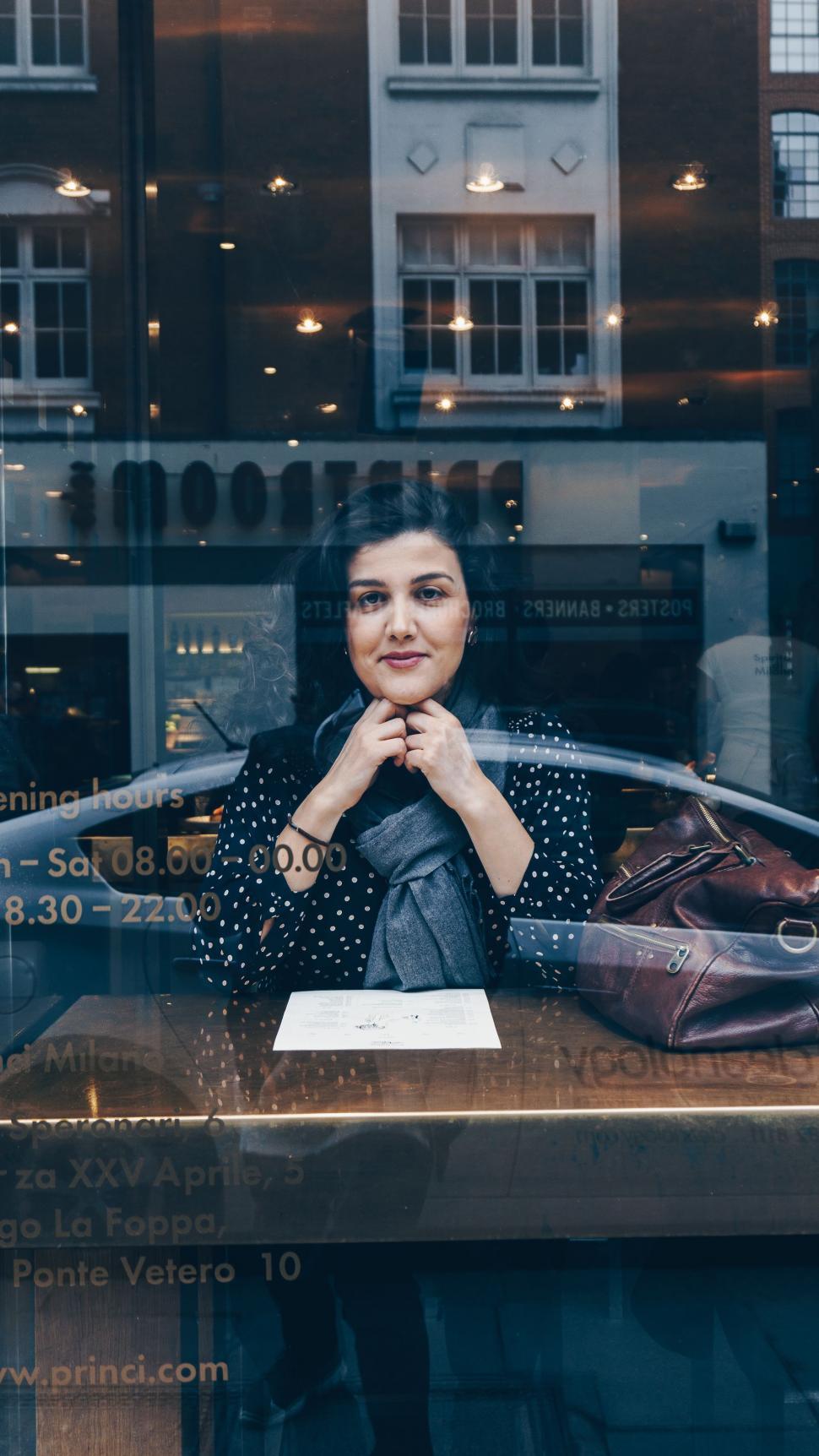 Free Image of Woman Sitting at Table in Front of Window 