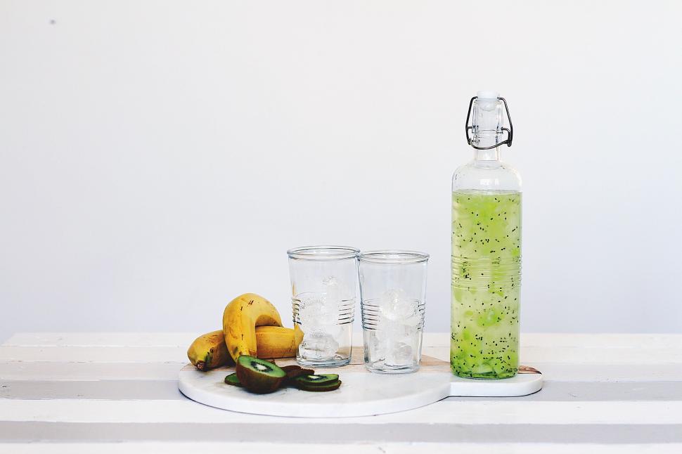 Free Image of Green Liquid Bottle Next to Three Glasses 