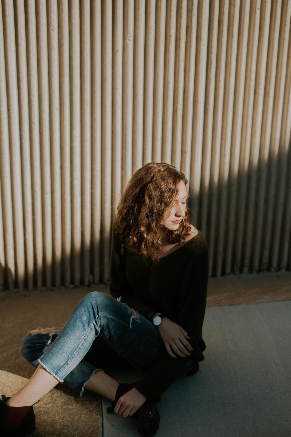 Free Image of Woman Sitting on Ground With Legs Crossed 