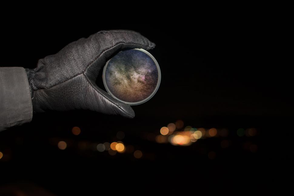 Free Image of Gloved Hand Holding Metal Object in the Dark 