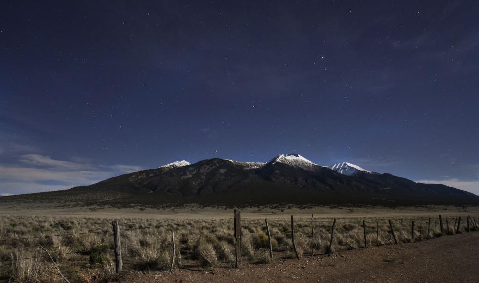 Free Image of Dirt Road With Fence and Mountain in Background 