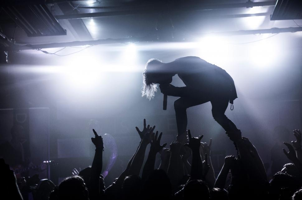 Free Image of Person Standing on Top of Crowd of People 