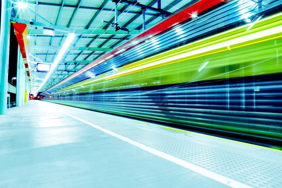 Free Image of Long Train Traveling Through Train Station 