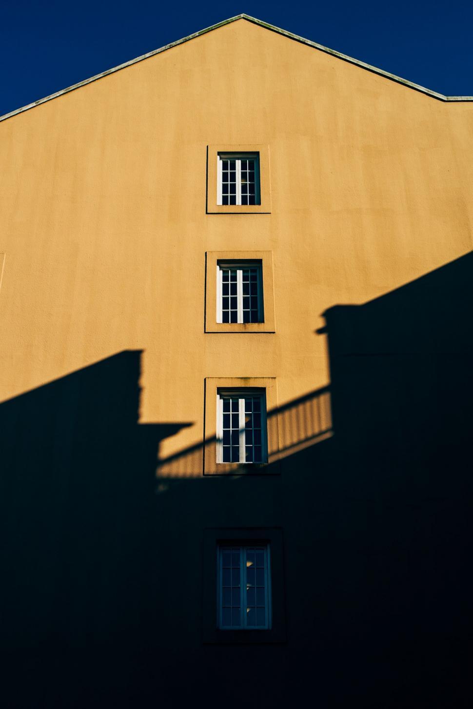 Free Image of Shadow of Building Cast on Ground on Sunny Day 