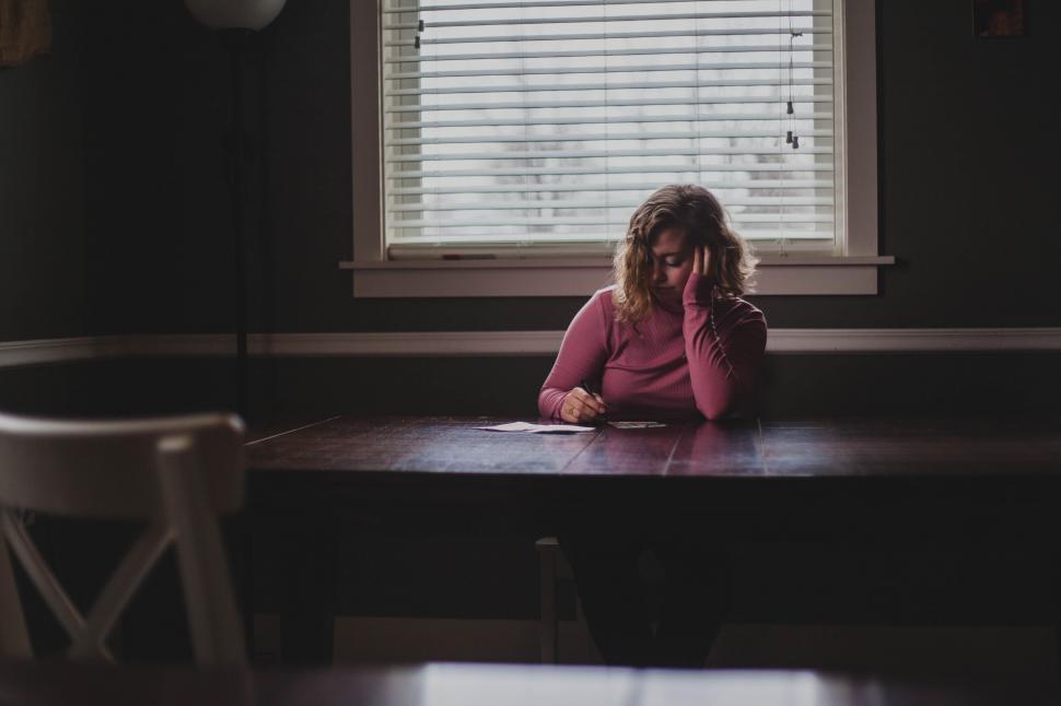 Free Image of Woman Sitting at Table by Window 