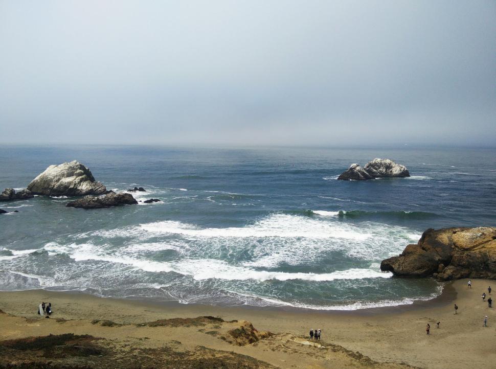 Free Image of Group of People Standing on Top of Sandy Beach 
