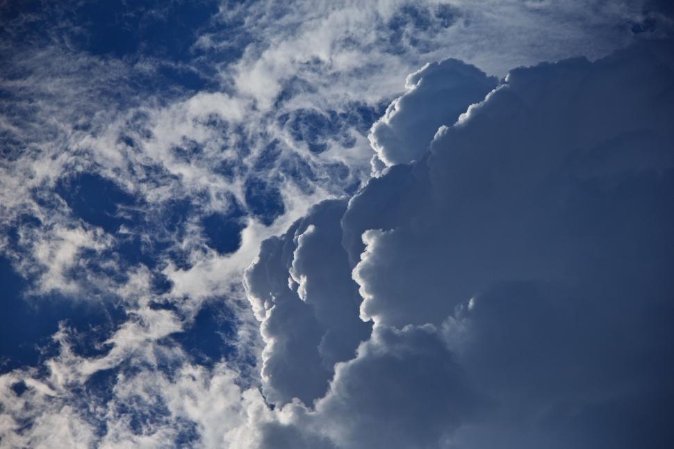 Free Image of Plane Flying Through Cloudy Blue Sky 