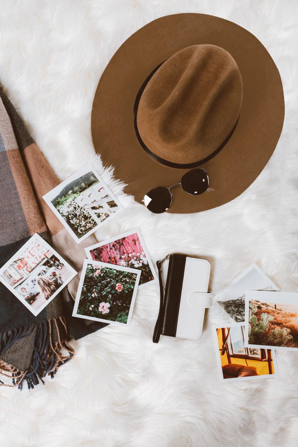 Free Image of Hat, Scarf, Sunglasses, and Photos on Blanket 