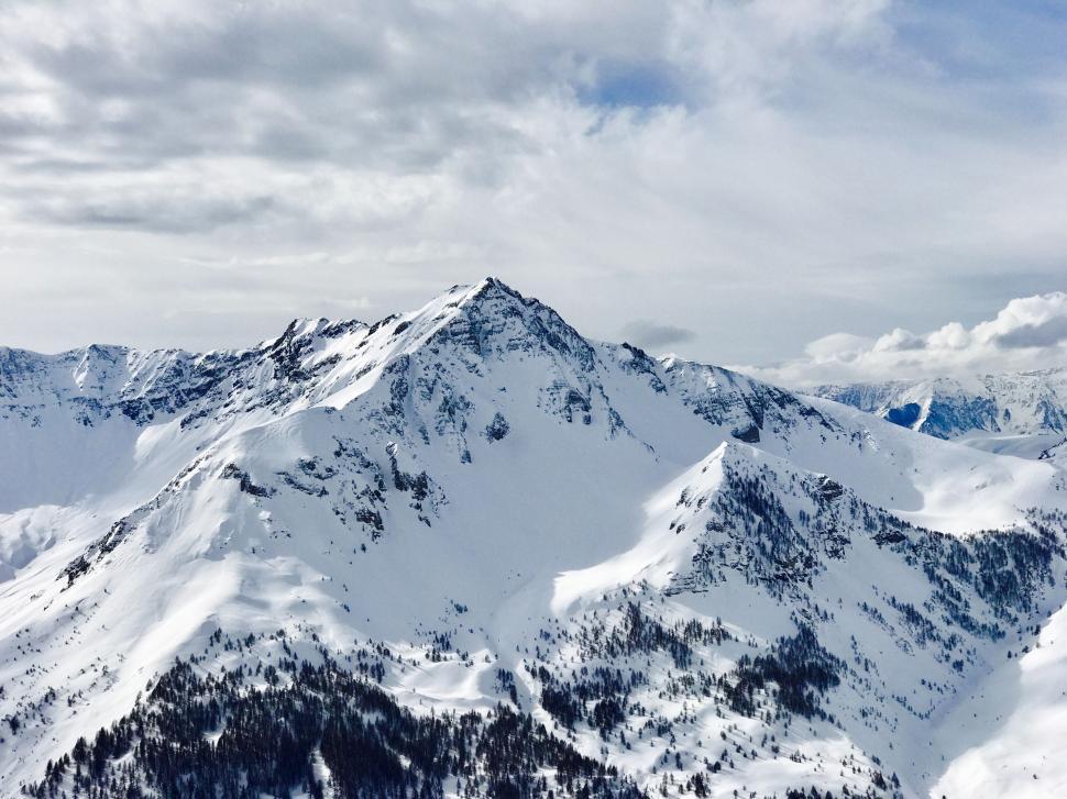 Free Image of Snow Covered Mountain Range Under Cloudy Sky 