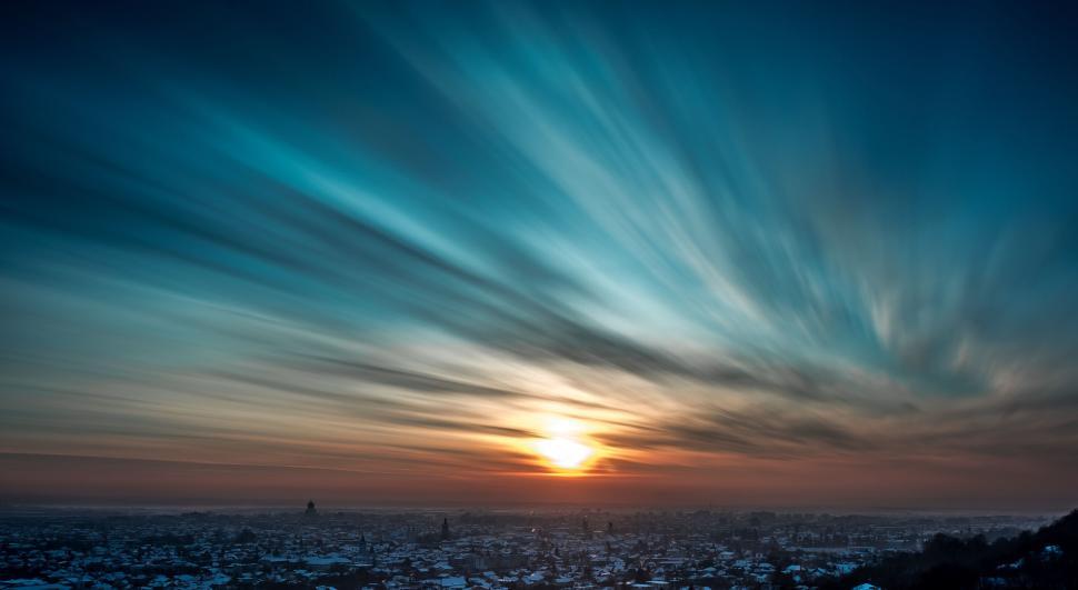 Free Image of Sun Setting Over City With Clouds 