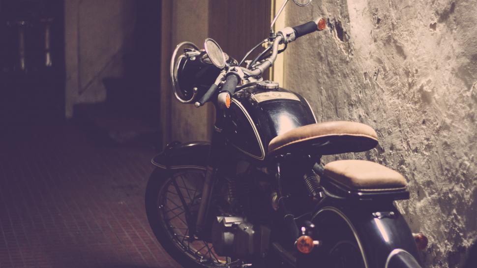 Free Image of Motorcycle Parked Next to Stone Wall 